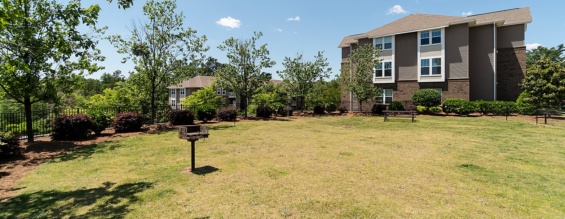 Grassy Area With Grill At The Vinings at Laurel Creek Apartments